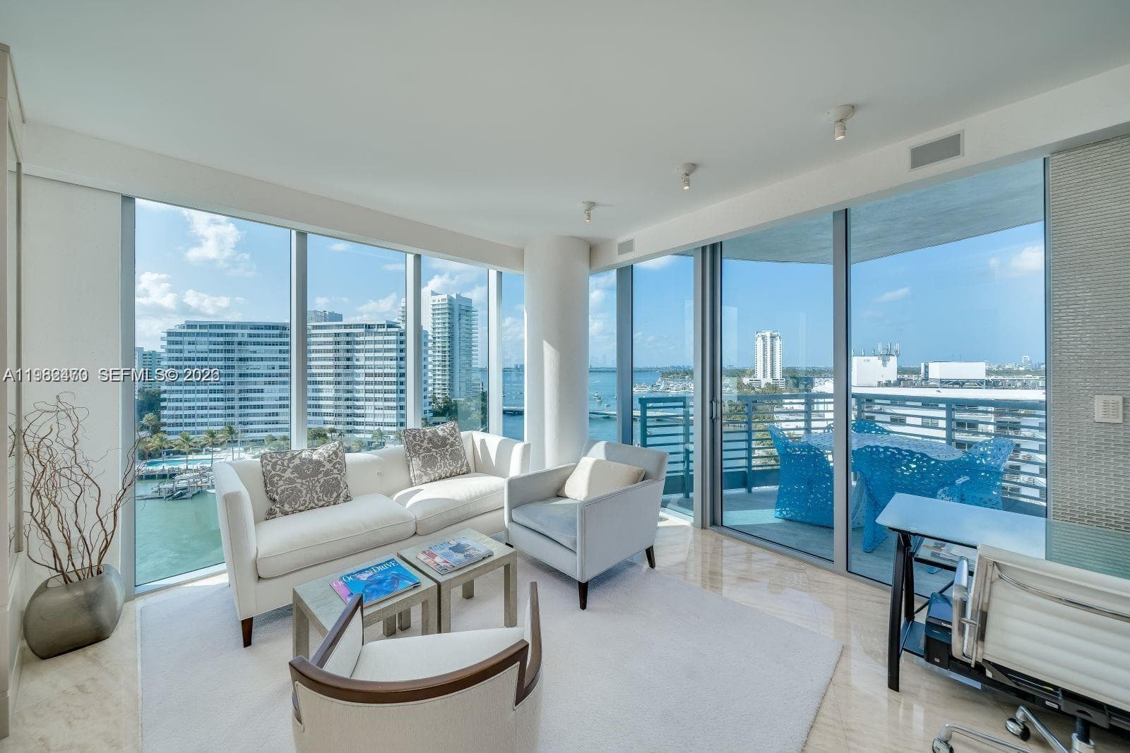 Floor-to-ceiling windows, access to a private balcony, polished tile flooring, recessed lighting, and a textured accent wall. Staged by former owner.