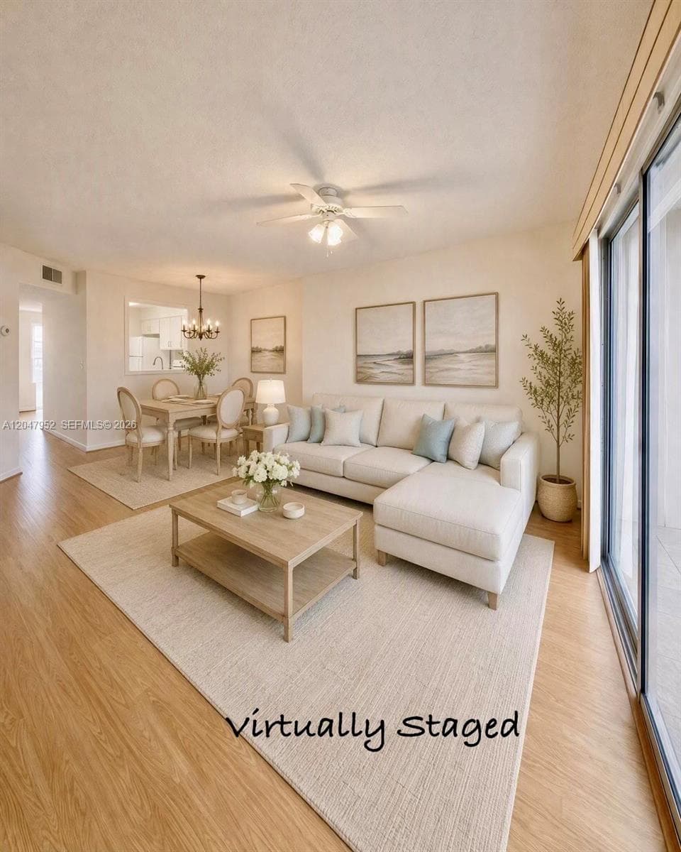 Wood-finish flooring, ceiling fan with integrated lighting, pass-through window, and sliding glass patio doors