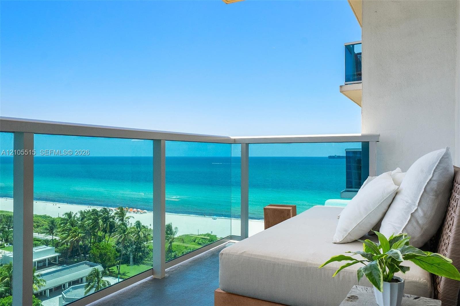 Private balcony with glass panel railing and unobstructed oceanfront exposure