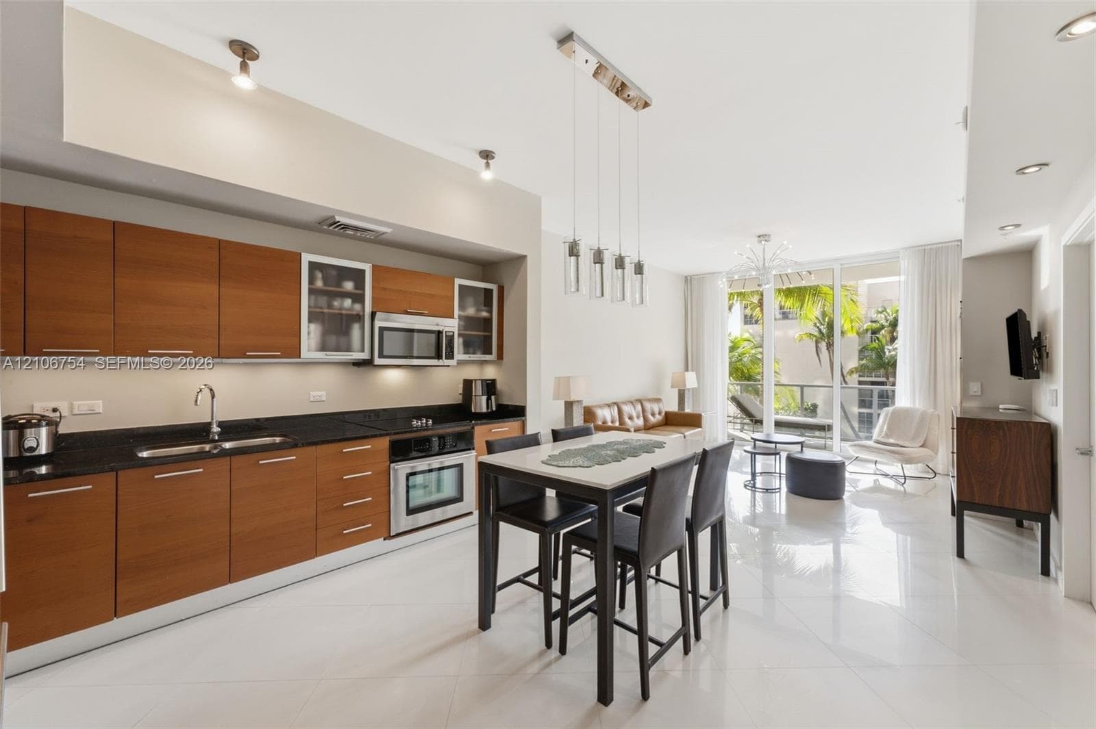Modern kitchen featuring wood-finish cabinetry, dark solid-surface countertops, built-in stainless steel appliances
