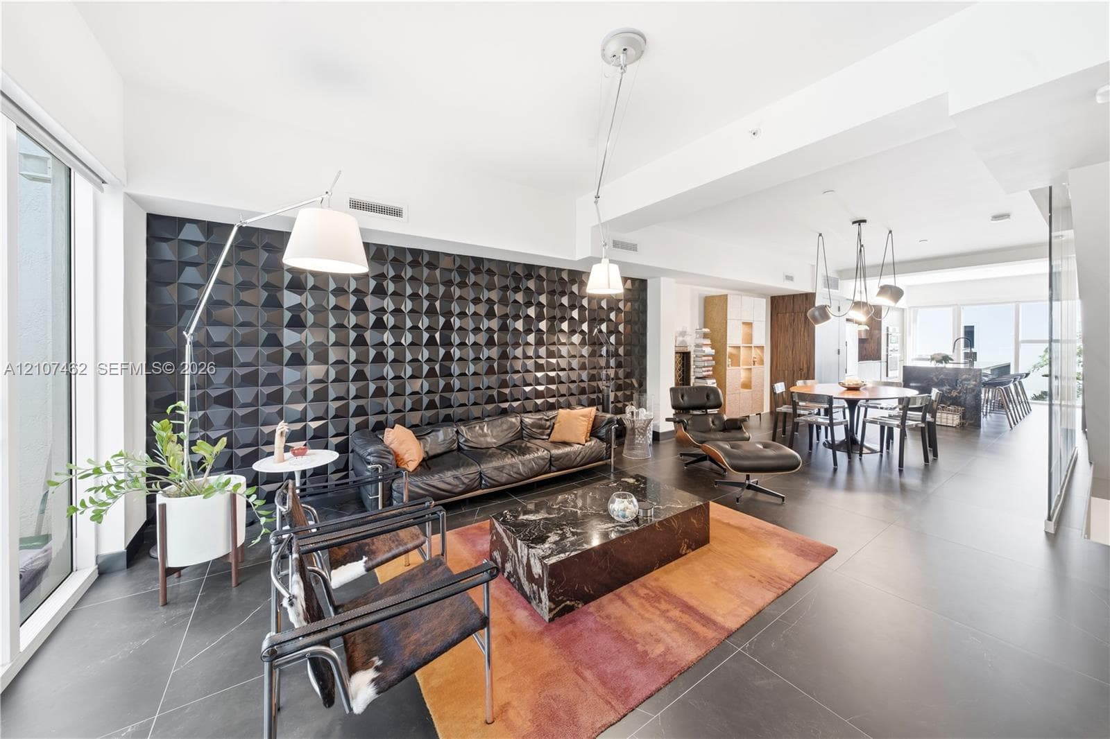 Textured black accent wall, large-format tile flooring, and integrated ceiling lighting fixtures