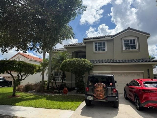 Two-story exterior featuring a stucco facade, multi-gabled roofline with tile roofing, grid-pattern windows, and an attached two-car garage