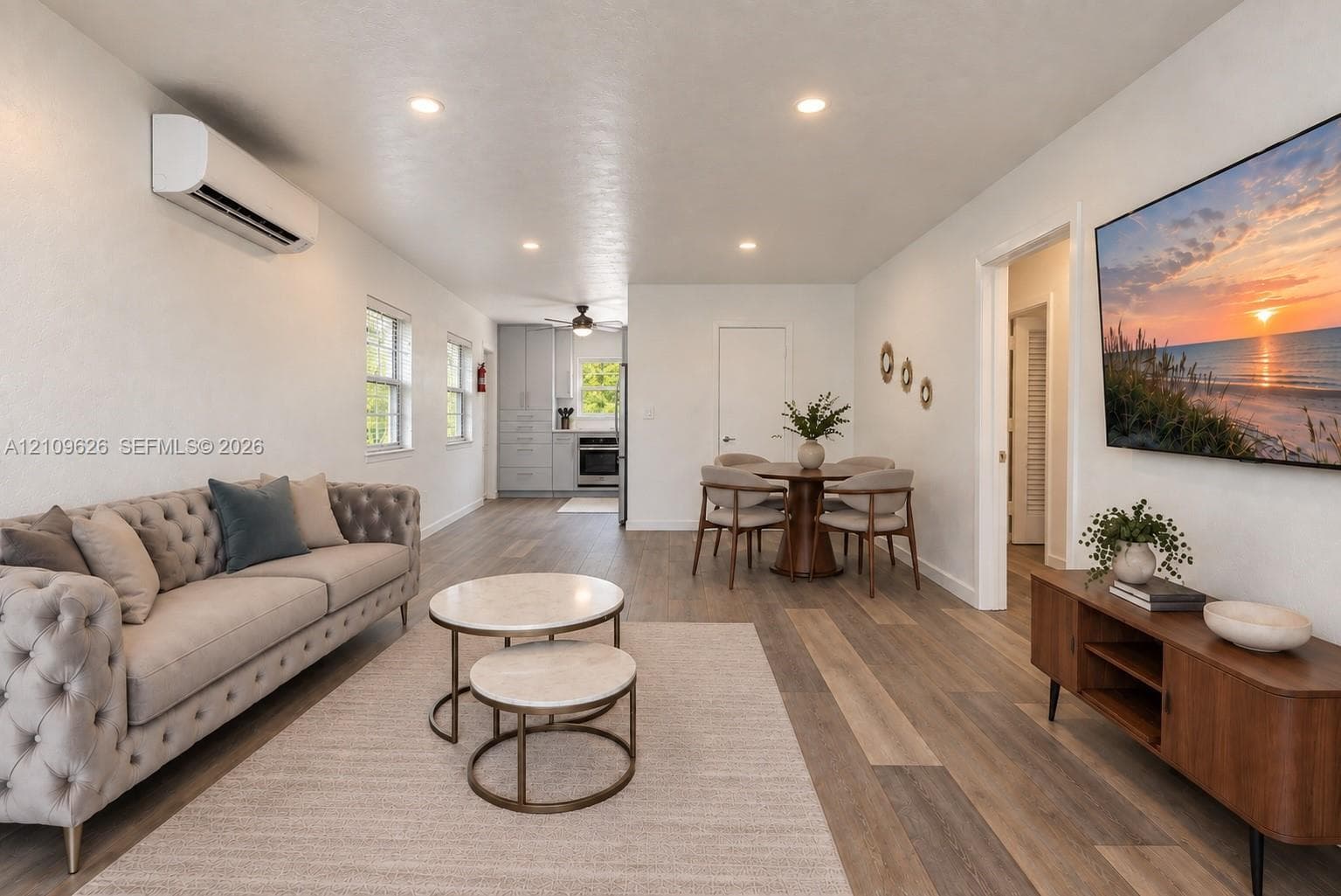 Open-concept interior featuring wood-finish flooring, recessed lighting, and a wall-mounted ductless heating and cooling unit