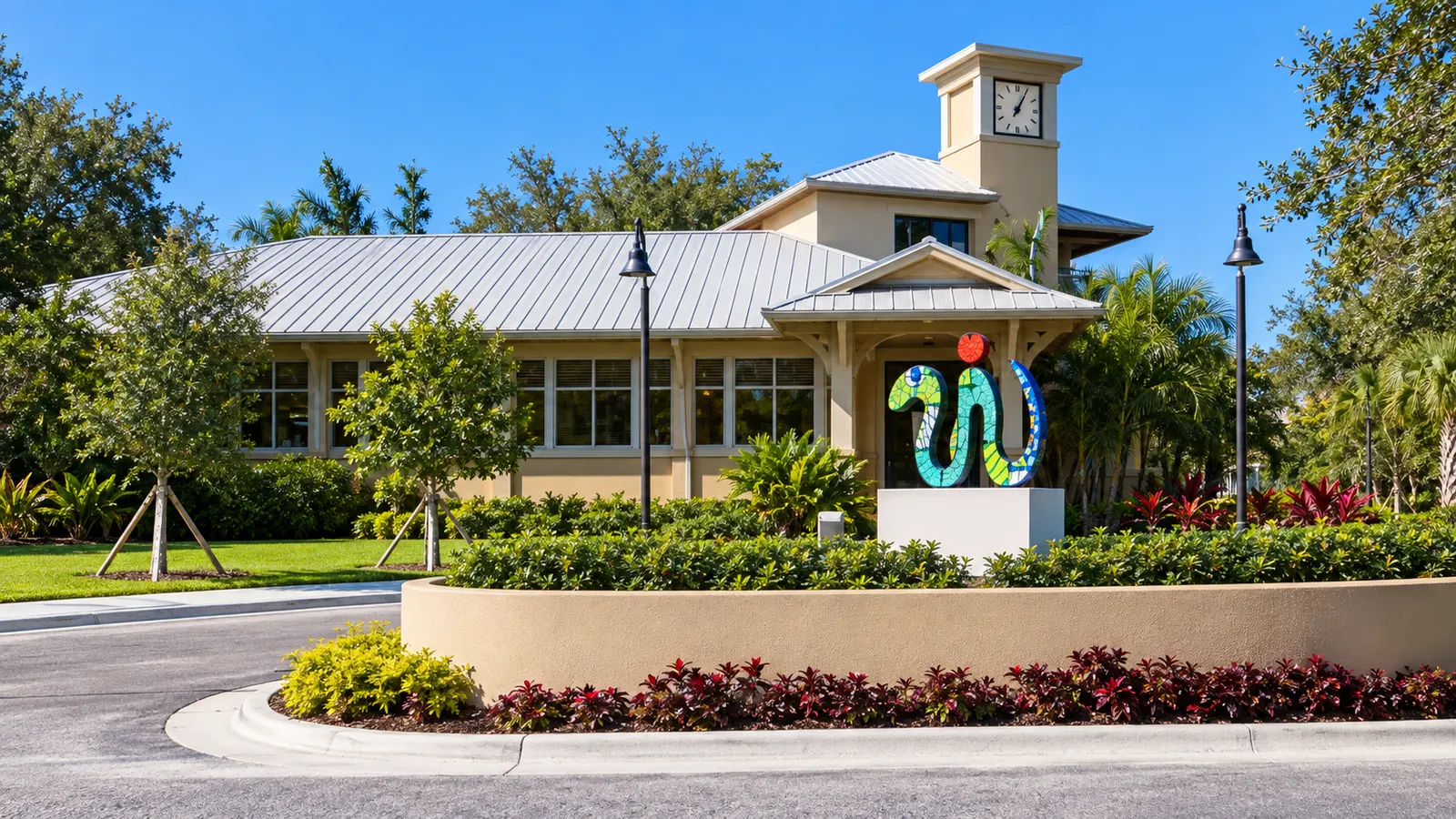 Illustrative view of Palmetto Bay Branch Library with clock tower and colorful sculpture at Ludovici Park
